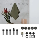 Assorted hardware kit with screws, bolts, nuts, washers, and O-rings arranged on a light background, plus a small olive bag and decorative plant on the left.