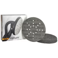 Boxed set of Mirka Iridium sanding discs with perforated surfaces and dust holes beside the box.