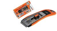MOTIVE SKROBAK DO SZYB MOTIVE Z OSTRZAMI ZAPASOWYMI 4cm (030 321) Orange-handled retractable utility knife with a metal blade and black slider, shown next to its orange packaging labeled 'ergo shape'
