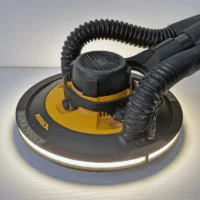 MIRKA Lampa szlifierska LED Halo do Mirka* Leros (IT-SL-ML) Polisher with a circular yellow and black base and attached flexible hose on a metal work surface. Makita brand visible on the pad edge.