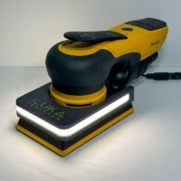 Yellow and black handheld sander resting on a white work surface, with a bright LED strip along the base plate.