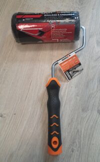 L’outil Parfait Liss Wkład wałka do gładzi 18 cm + MOTIVE UCHWYT MALARSKI SOFT 18cm/8mm (dł. 33cm) (PB18) Paint roller with a black and orange ergonomic handle, curved metal frame, and a wrapped roller cover; packaging notes 180 mm width.