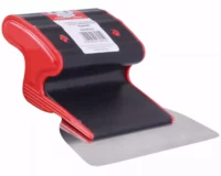 Close-up of a red and black handheld paper cutter resting on a metal cutting surface.