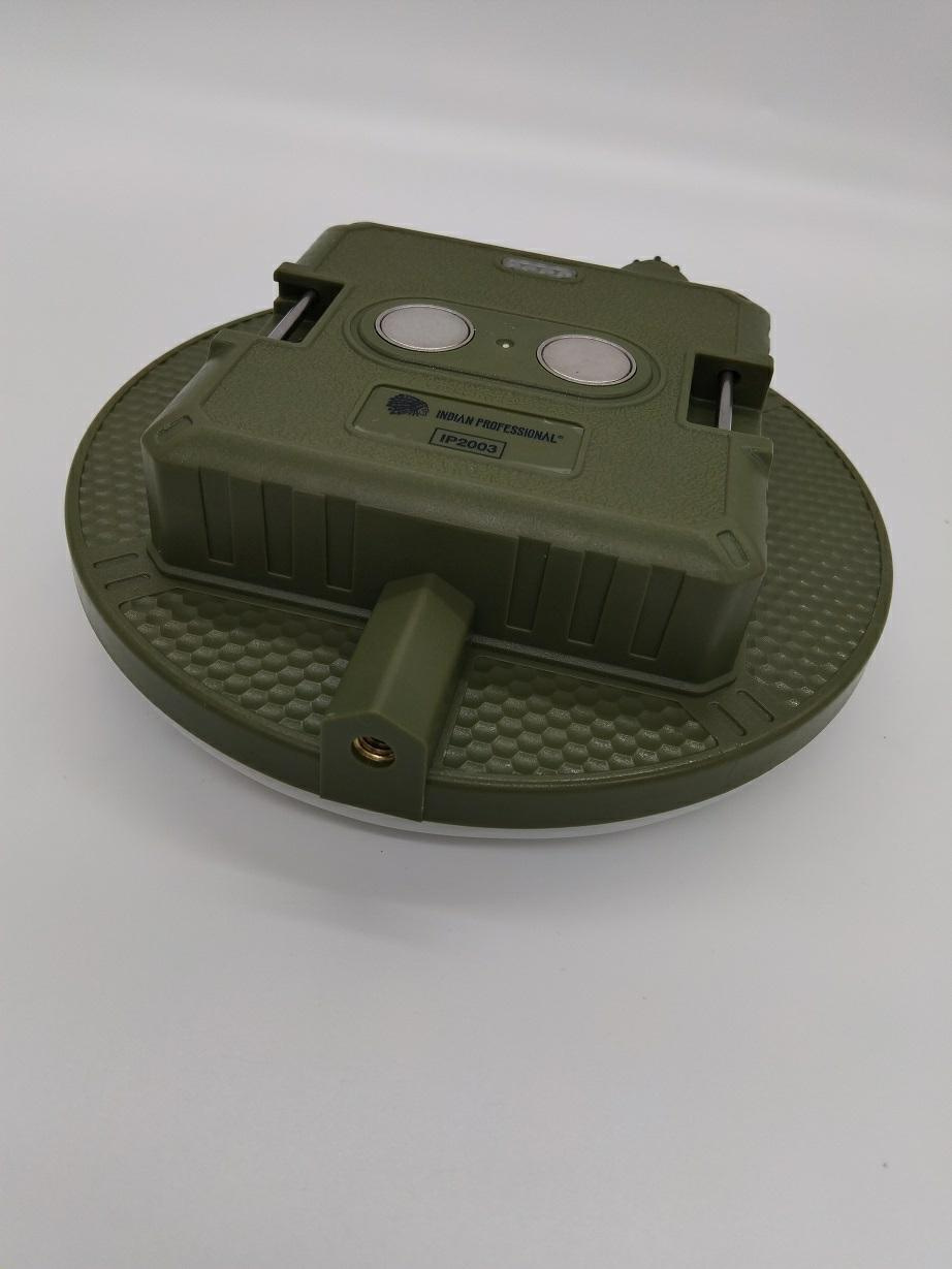 ROLLINGDOG, Latarka LED powerbank 4500 mAh USB C IP2003 INDIAN PROFESSIONAL (IP2003) Circular olive-green platform with a textured edge and a rectangular green module mounted on top, featuring two round metal dials and a small label.