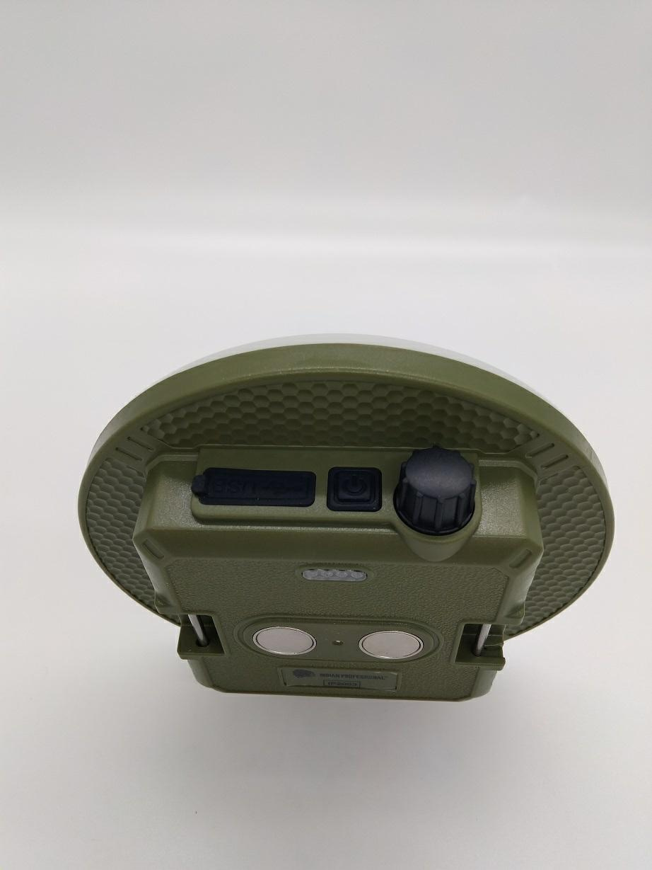 ROLLINGDOG, Latarka LED powerbank 4500 mAh USB C IP2003 INDIAN PROFESSIONAL (IP2003) Olive-green circular electronic device with a textured rim, mounted on a rectangular base with a power switch, knob, and two circular contact pads.